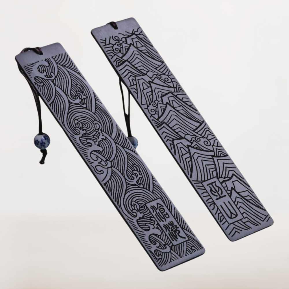 Duo de marque pages bois foncé gravés de montagnes et de vagues, élégance raffinée pour lectures poétiques.
