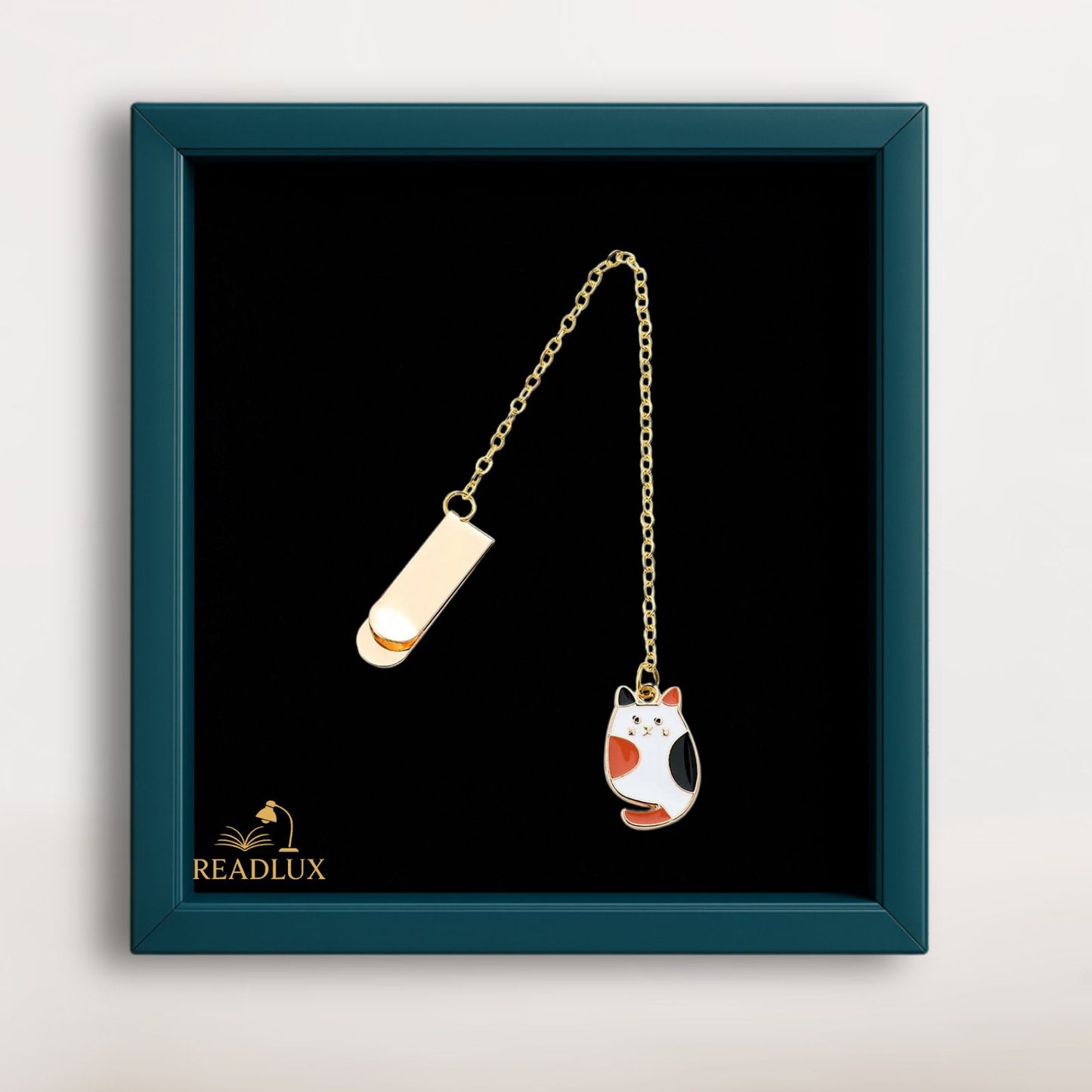 Bijou marque page doré avec pendentif chat tricolore émaillé, élégant accessoire pour roman ou carnet.