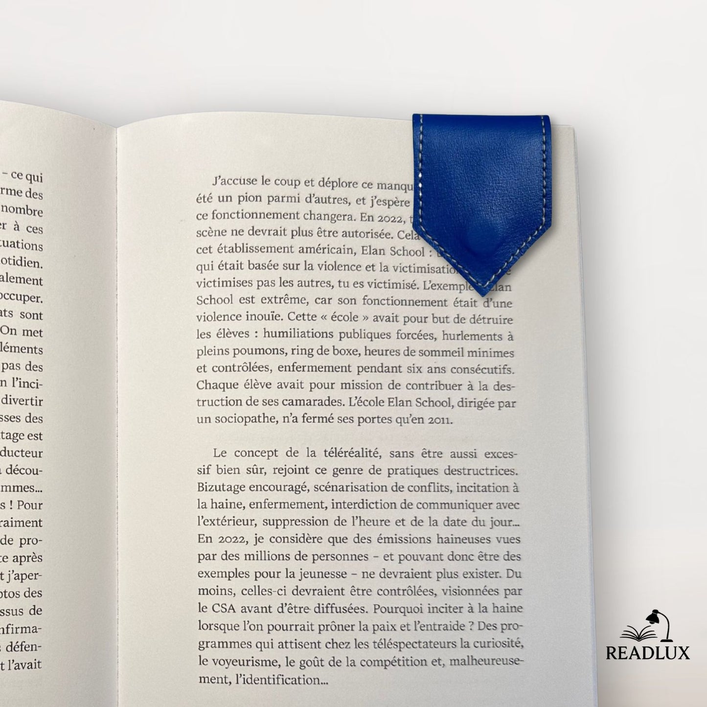 Un marque-page en cuir bleu, en forme de flèche, posé sur une page d'un livre ouvert