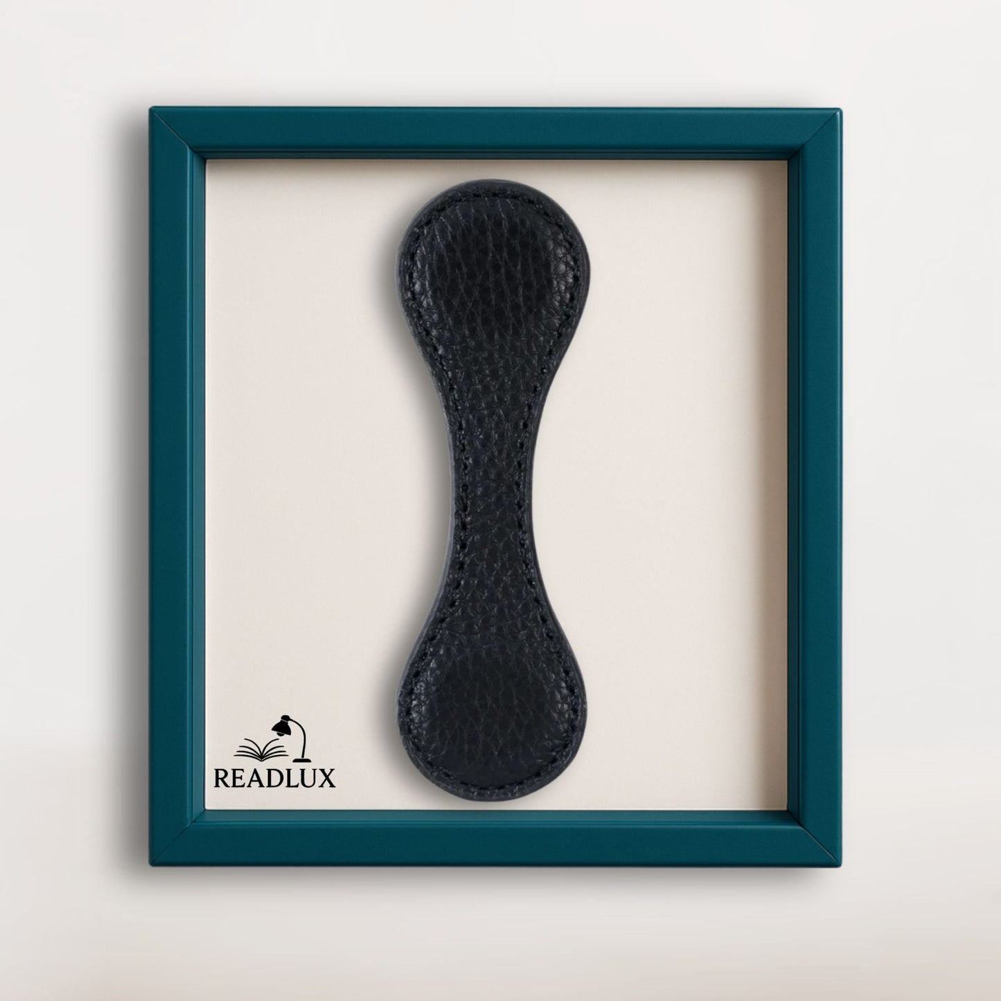 Marque-page en cuir noir, au design élégant, présenté dans un cadre turquoise sur fond clair