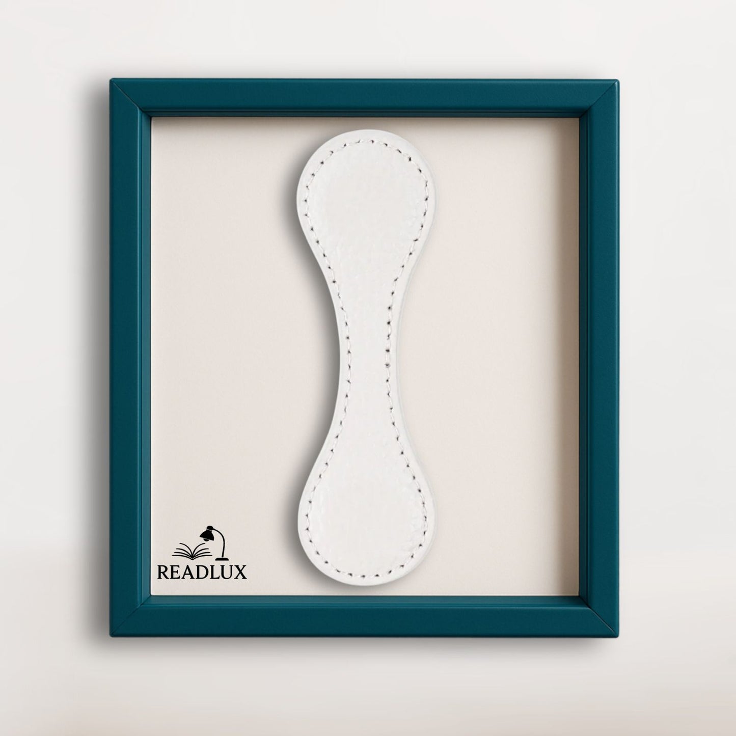 Marque page magnétique en cuir blanc texturé, présenté dans un cadre élégant bleu canard signé Readlux
