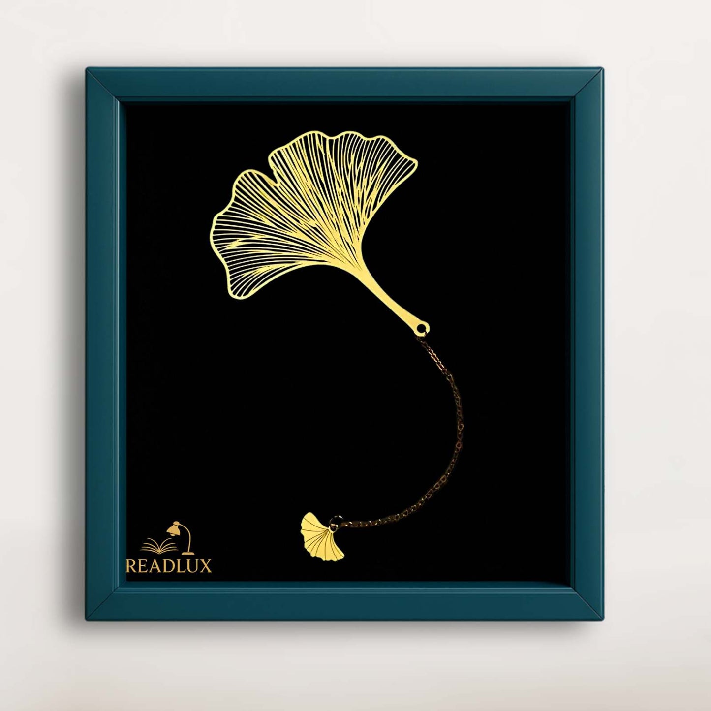 Marque page en métal doré en forme de feuille de ginkgo, sur fond noir avec chaînette assortie