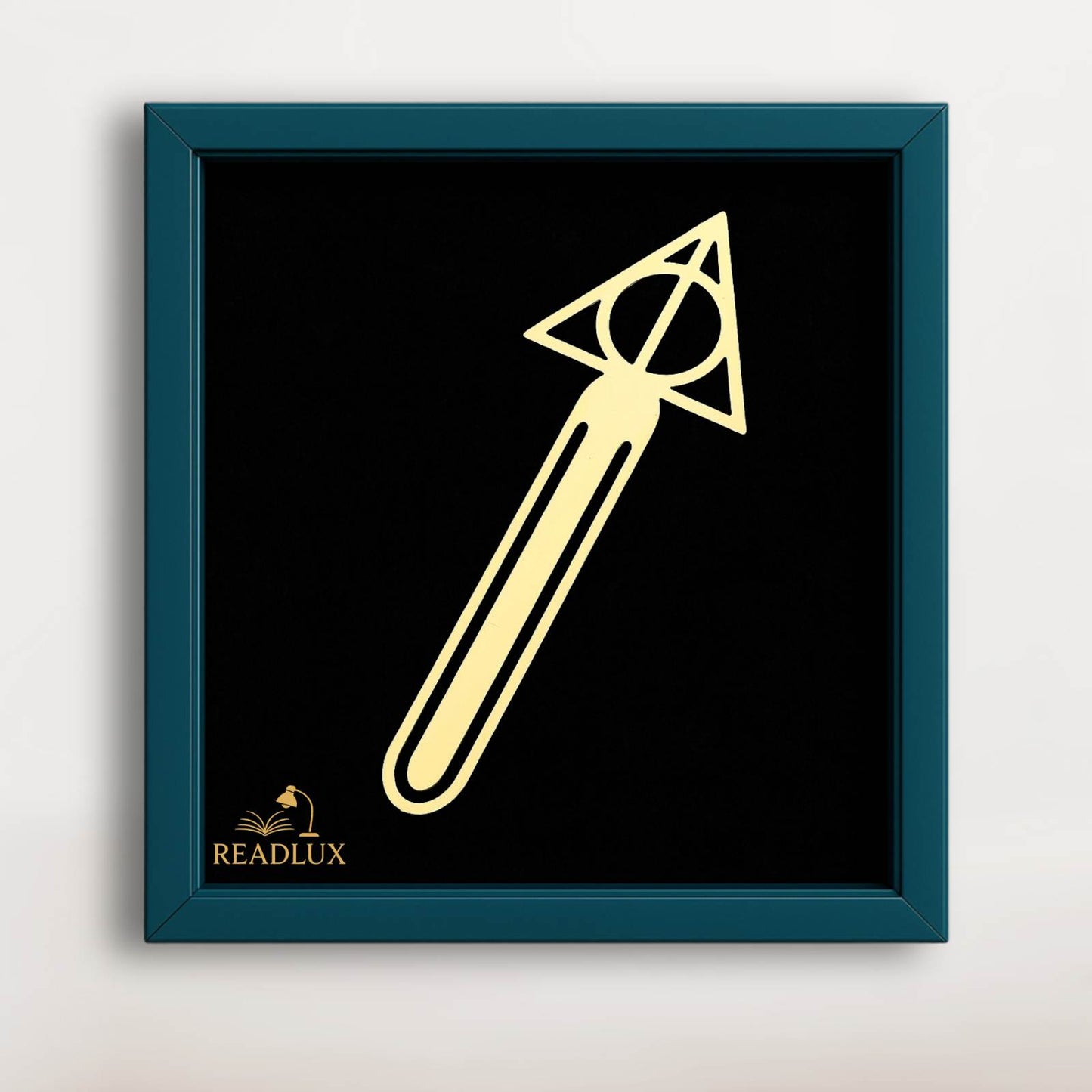 Marque-page en métal doré en forme de flèche, sur fond noir, avec un cadre bleu élégant