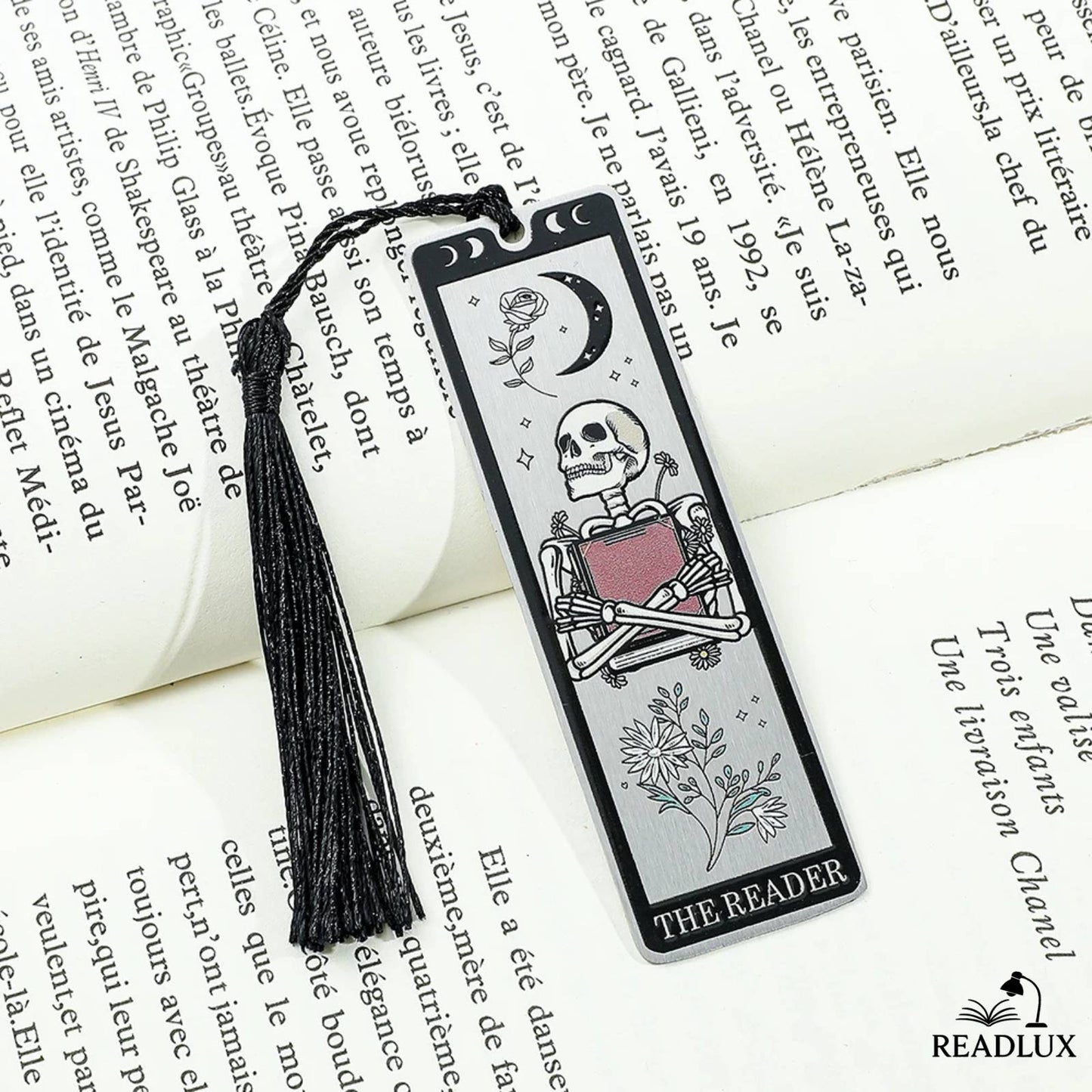 Marque-page squelette lecteur avec motifs lunaires et pompon noir, style gothique sur un livre