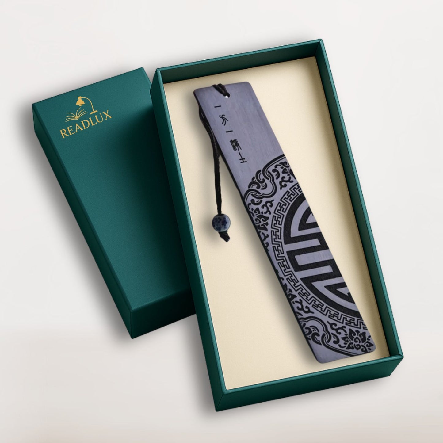 Marque-page en bois redwood gravé, motif graphique noir avec cordon et perle bleue, signé Readlux
