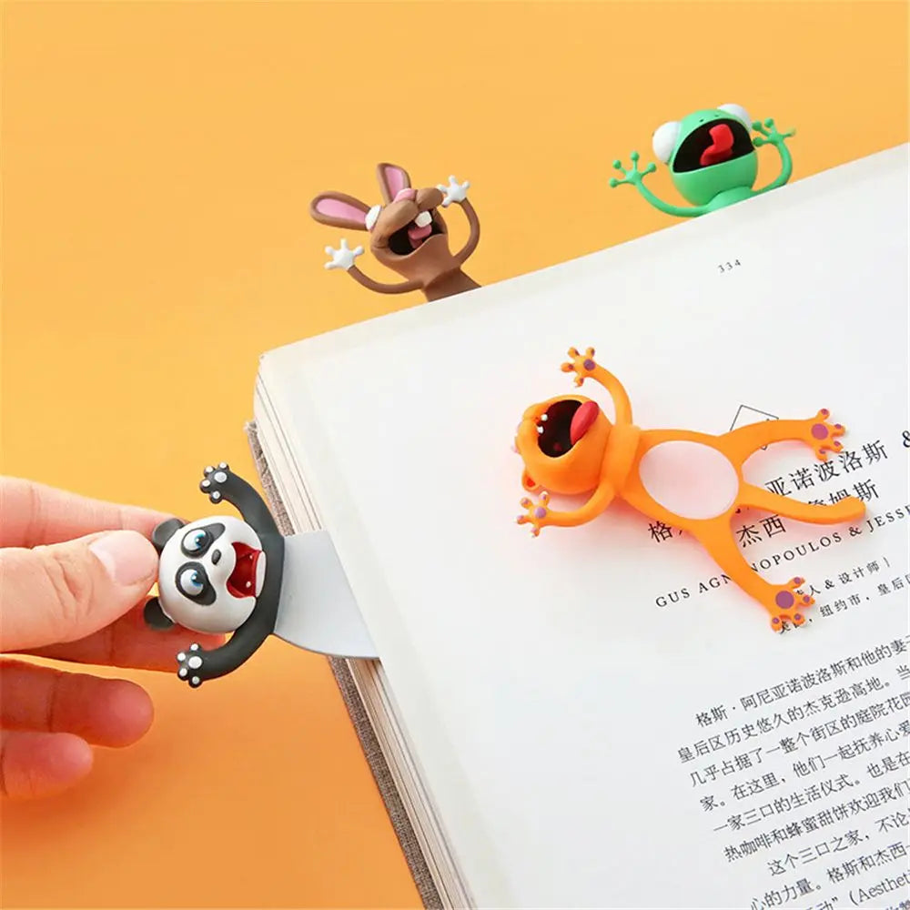 Des marque-pages en forme d'animaux colorés, dont un panda, un lapin et une grenouille, sur une page de livre
