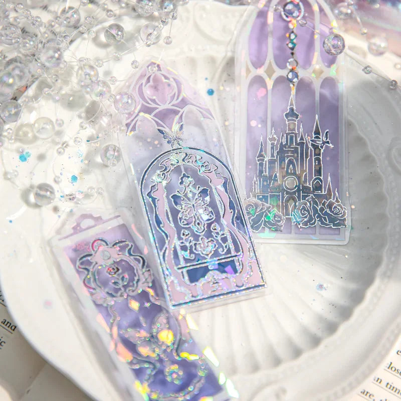 Trois marque-pages en PVC aux motifs holographiques, avec des couleurs pastel et un décor de château féerique