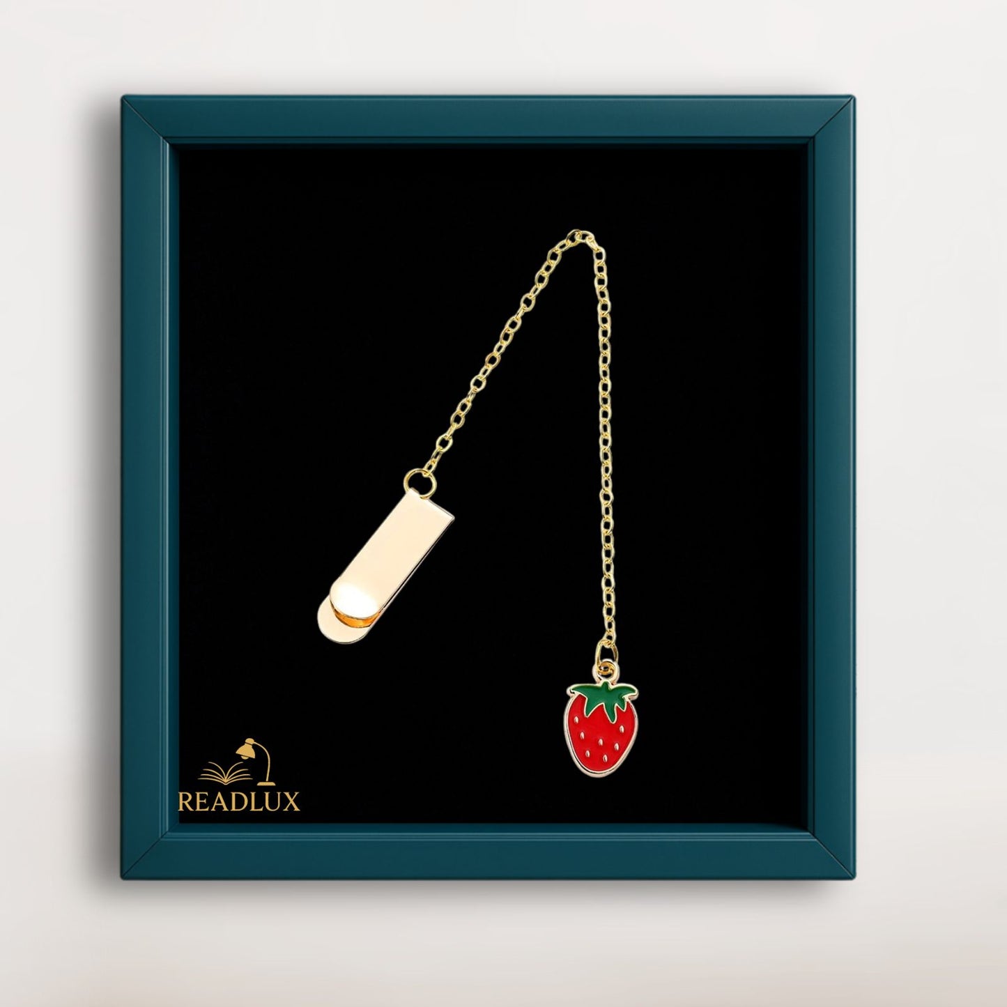 Bijou marque page doré avec pendentif fraise rouge émaillée, accessoire fruité pour roman ou carnet.