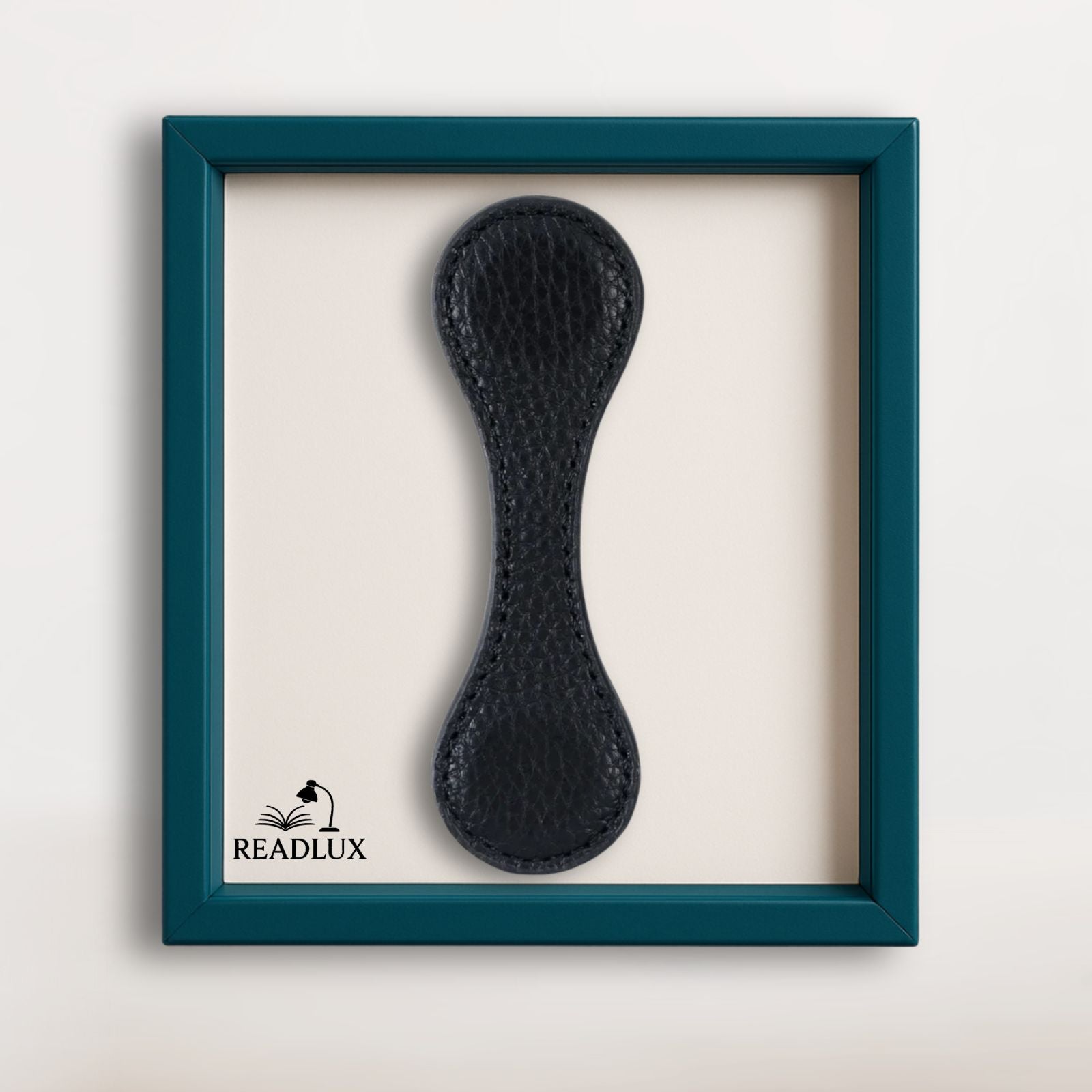 Marque-page en cuir noir, au design élégant, présenté dans un cadre turquoise sur fond clair