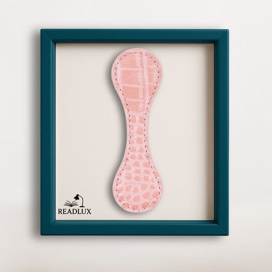 Marque page magnétique en cuir rose effet croco, présenté dans un cadre élégant bleu canard signé Readlux