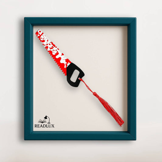 Marque-page scie rouge et blanche avec poignée noire et pompon rouge suspendu.