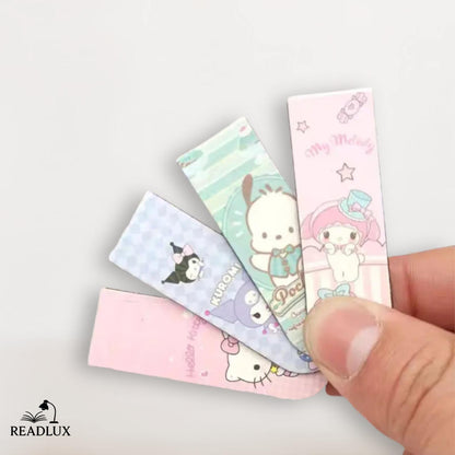 Main tenant des marque pages kawaii magnétiques avec Hello Kitty, Kuromi, Pochacco et My Melody en motifs pastel.