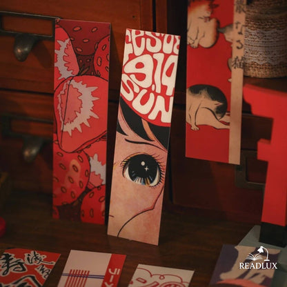 Marque-pages vintage japonais avec motifs rouges, illustrations de fraises et de personnages sur fond en bois