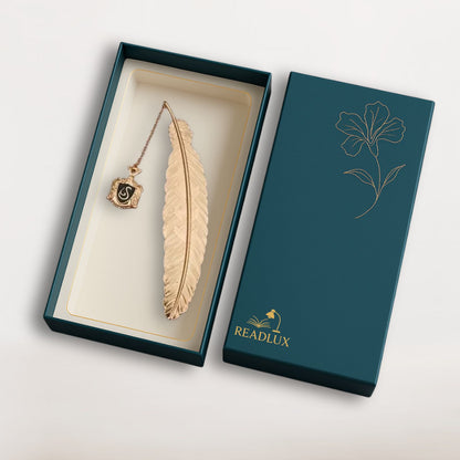 Marque page plume dorée en métal avec insigne noir suspendu, style sorcier élégant, mystérieux et symbolique