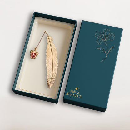 Marque page plume dorée en métal avec blason rouge suspendu, finition fine, style magique discret et raffiné