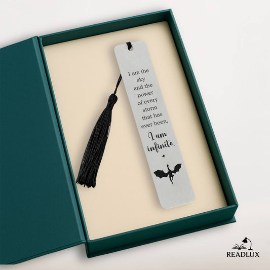Marque-page en acier inoxydable avec une frange noire, texte en noir et motif de dragon sur fond clair
