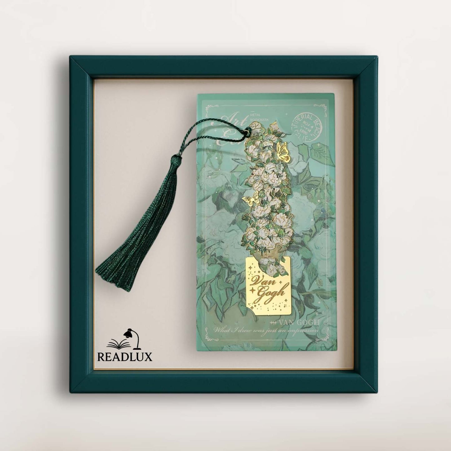 Marque-page vintage en métal avec un long pompon vert, décoré de motifs floraux sur fond turquoise