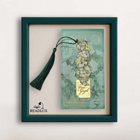 Marque-page vintage en métal avec un long pompon vert, décoré de motifs floraux sur fond turquoise