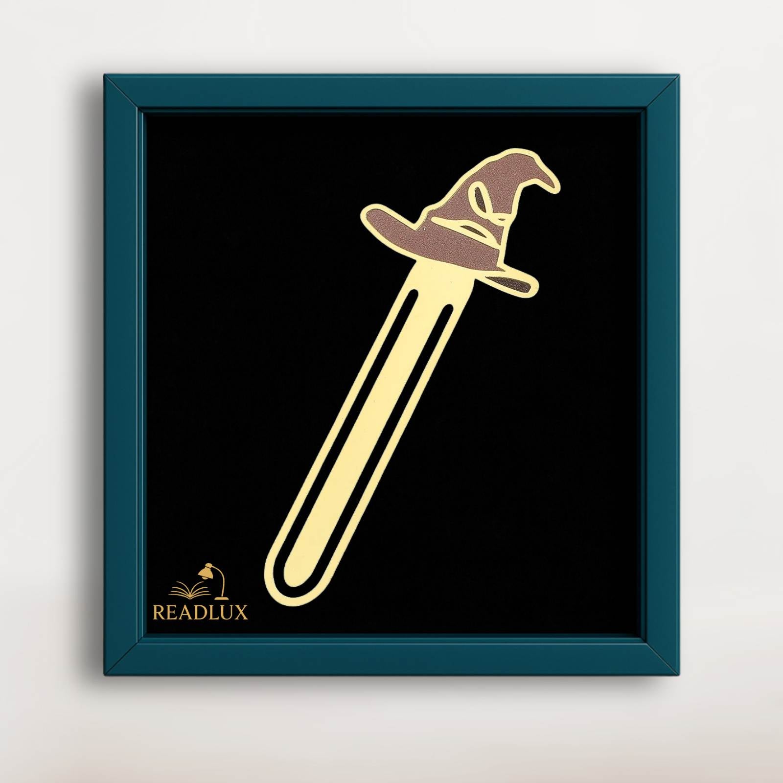 Marque-page en métal doré représentant un chapeau de sorcier sur fond noir, dans un cadre bleu