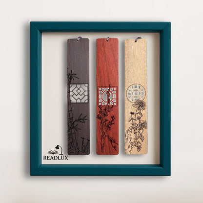 Lot de trois marque-pages en bois foncé, rouge et clair avec gravures florales et découpes géométriques, signé Readlux

