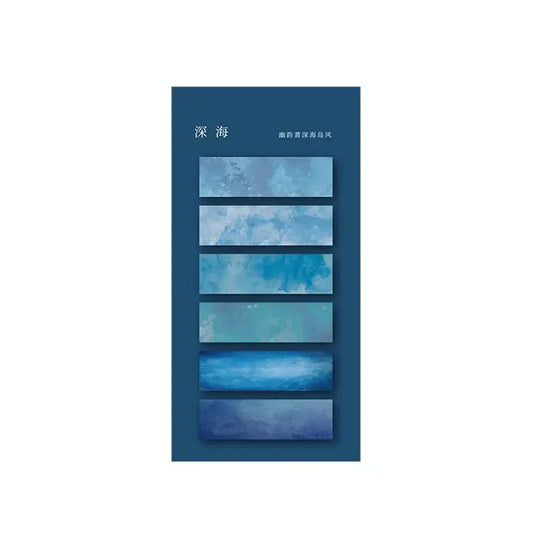 Des onglets autocollants transparents de différentes nuances de bleu, présentant des motifs aquatiques sur un fond bleu foncé