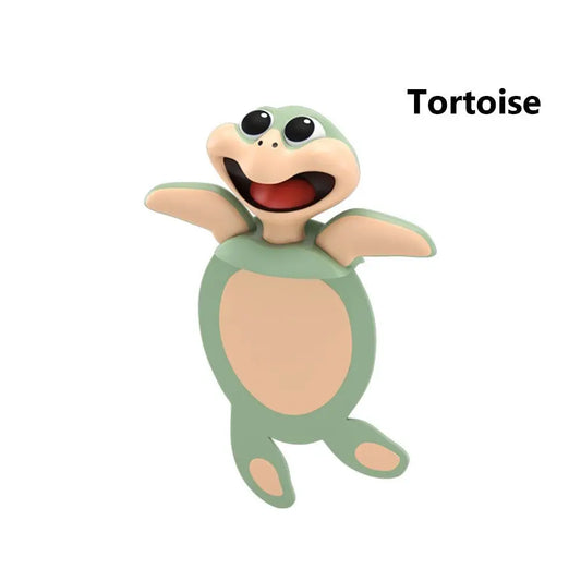Un marque-page en forme de tortue souriante, avec des couleurs vertes et beige, aux yeux ronds et expressifs
